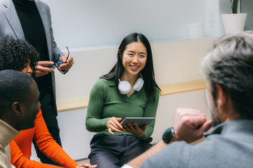 Team collaboration session with diverse group and tablet