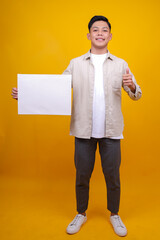 Young Asian Man In Casual Style Smiling And Showing Blank White Board While Showing Thumb Up