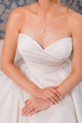 Elegant bridal hands with diamond ring in satin robe.