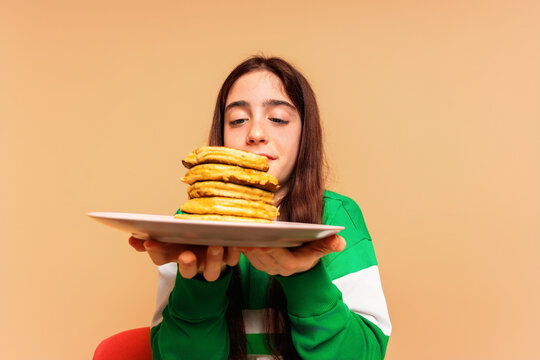 Girl Holding Plate of Pancakes