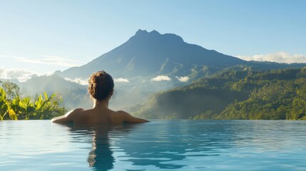 Woman Relaxes In Infinity Pool Overlooking Majestic Mountain