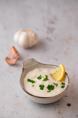 Lebanese Garlic sauce Toum or Salsat toum contains garlic, salt, olive oil and lemon juice. Traditional Middle East food. Food photography.