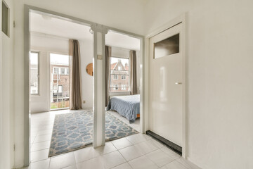 Fototapeta premium Stylish interior showing an inviting hallway filled with natural light, leading to a cozy bedroom decorated in soft tones.