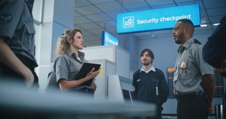 Airport Staff Briefing: Female TSA Officer with Tablet Computer Wearing Headset Instructs Group of...