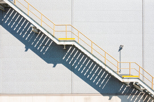Factory Building Exterior with Metal Staircase and Shadow Patter
