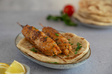 Chicken Kofta Kebab on wooden skewers with pita, garlic sauce Toum, parsley and lemon. Chicken skewers, shish kafta tavuk. Traditional Middle East food. Lebanese, Turkish cuisine. Food photography.