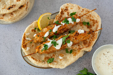 Chicken Kofta Kebab on wooden skewers with pita, garlic sauce Toum, parsley and lemon. Chicken skewers, shish kafta tavuk. Traditional Middle East food. Lebanese, Turkish cuisine. Food photography.