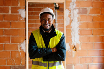 A smiling engineer in helmet and vest