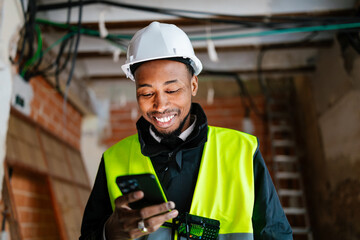 Smiling engineer using a smartphone