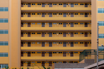 Symmetrical facade of a modern apartment building with repeating balconies and doors