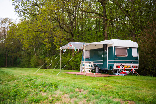 Green Caravan with Bicycle in Peaceful Nature Setting