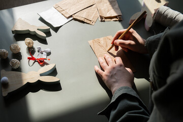 DIY process of woman making candid Easter present paper bag bunny arrangement decor. Series of...