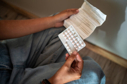 Woman Reading Medication Instructions of birth control pill