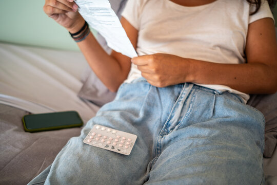 Woman Reading Medication Instructions of birth control pill
