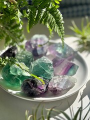 A stunning fluorite  crystal in sunlight, surrounded by greenery. Known for healing, clarity, and...
