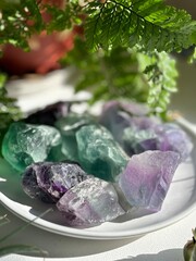 A stunning fluorite  crystal in sunlight, surrounded by greenery. Known for healing, clarity, and...