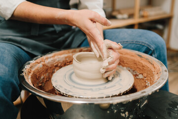 Fototapeta premium Process of making a unique ceramic shape. Potter creates a ceramic bowl in the pottery studio.