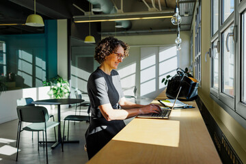 Formal businesswoman working on laptop in modern office space