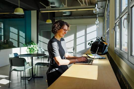 Formal businesswoman working on laptop in modern office space