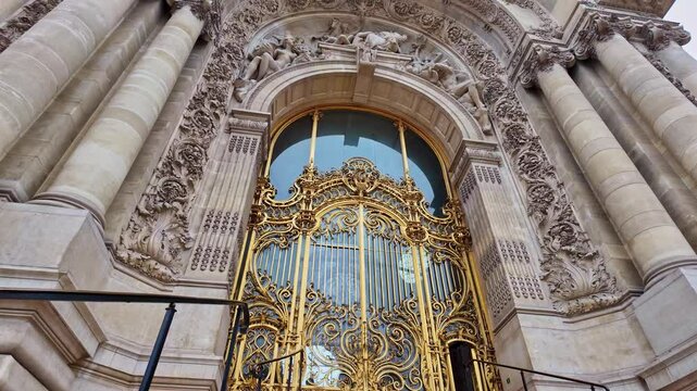 The famous Petit Palais art museum gilded main entrance gate with artistic stone carvings, Paris, France.