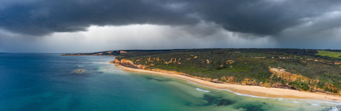 Dark stormfront over long coastline