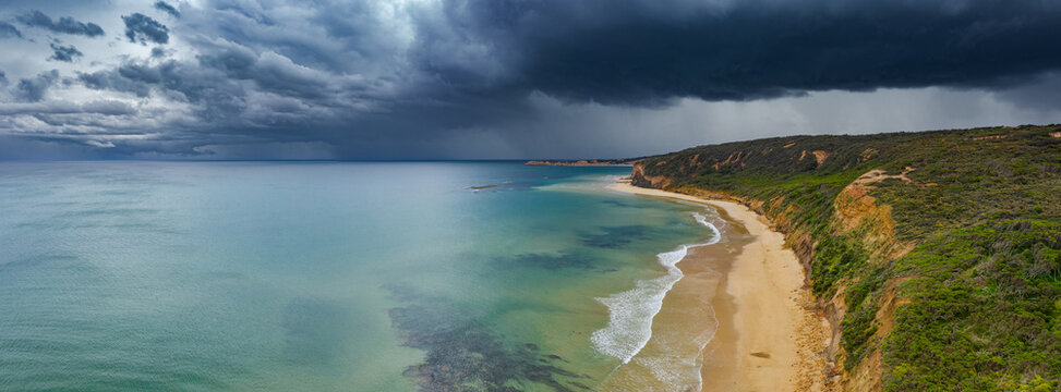 Dark stormfront over long coastline