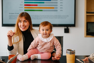Businesswoman with baby at office meeting embracing work-life balance