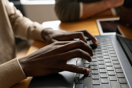 Person typing on laptop keyboard in a cozy workspace setting