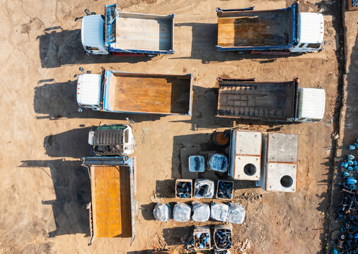 Aerial View of Dump Trucks and Construction Materials on Dirt Gr