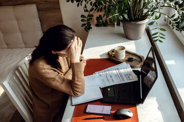 Middle-aged woman paying utility bills from home.