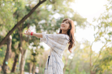 cheerful woman in plaid shirt enjoys sunny day outdoors, surrounded by lush greenery and soft...