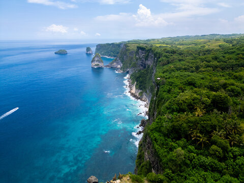 Stunning cliffside view at Manta Point, Nusa Penida – turquoise waters crashing against rugged limestone cliffs under a bright blue sky