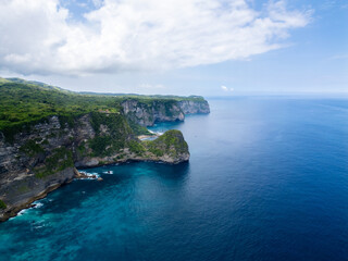 Stunning cliffside view at Manta Point, Nusa Penida – turquoise waters crashing against rugged limestone cliffs under a bright blue sky