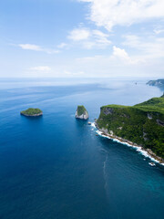 Naklejka premium Stunning cliffside view at Manta Point, Nusa Penida – turquoise waters crashing against rugged limestone cliffs under a bright blue sky