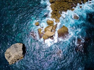 Stunning cliffside view at Manta Point, Nusa Penida – turquoise waters crashing against rugged limestone cliffs under a bright blue sky