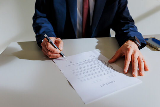 Business professional signing important contract document