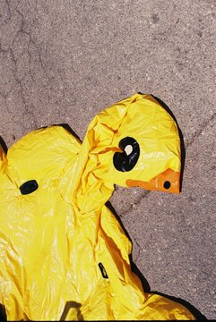 Deflated Yellow Inflatable Duck on Pavement
