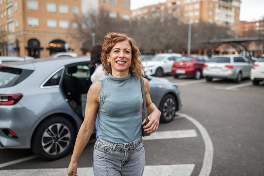 multiracial friends getting out of a car after parking in a parking 