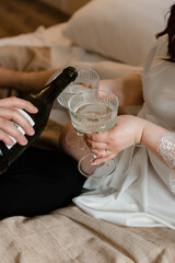 Glasses of champagne in the hands of the bride and groom, close-up