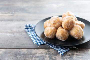 Traditional Carnival fritters or buñuelos de viento on wooden table. Copy space