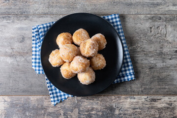 Traditional Carnival fritters or buñuelos de viento on wooden table. Top view