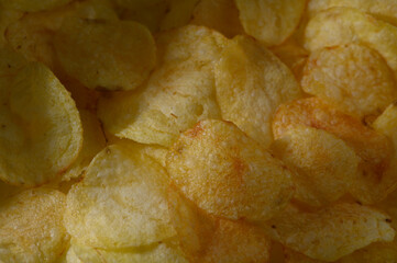 Crunchy golden potato chips piled high in a bowl, perfect for snacking at any casual gathering or party