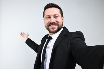Happy businessman welcoming clients or partners on grey background, view through front camera of gadget