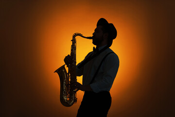 Professional musician playing saxophone on color background, backlit