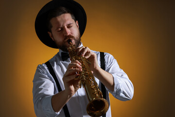 Naklejka premium Professional musician playing soprano saxophone on color background