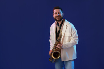 Professional musician with saxophone on blue background