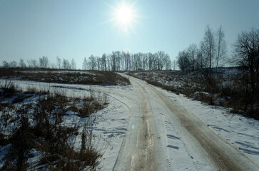 Obraz premium Snow-covered dirt road on a clear day