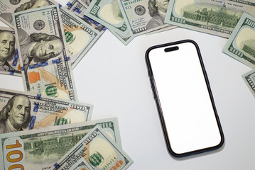 Currency arranged around a smartphone on a white surface in a composition on the theme of money, business, marketing, bank