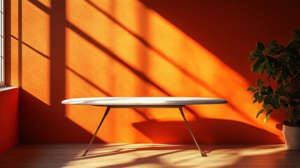 A vibrant orange backdrop provides a striking contrast to a sleek minimalist ironing board, its silhouette subtly framed by soft shadows that dance across the well-lit space, creating a sense of