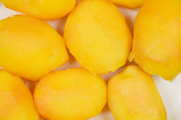 A close-up, top-down shot of several cooked yellow potatoes, revealing their texture and golden hue